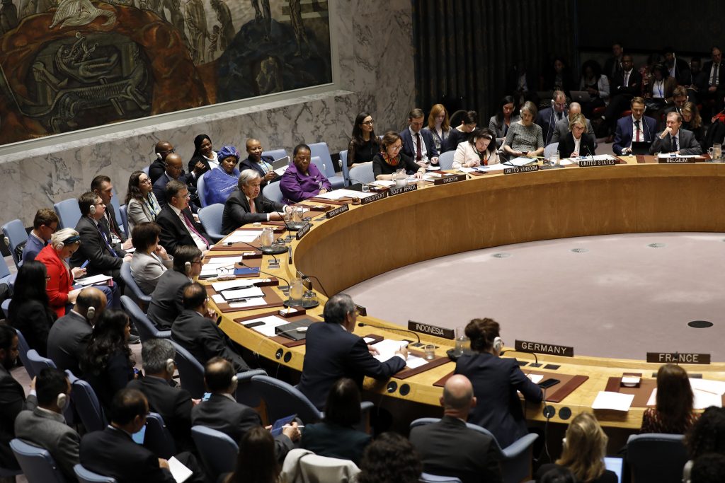 Kvinnor och män med namnskyltar från olika länder i en stor sal