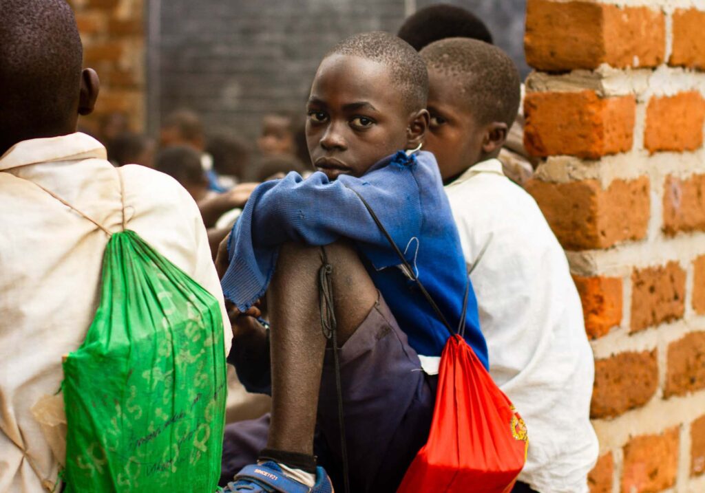 Skolpojkar i Tanzania på en mur