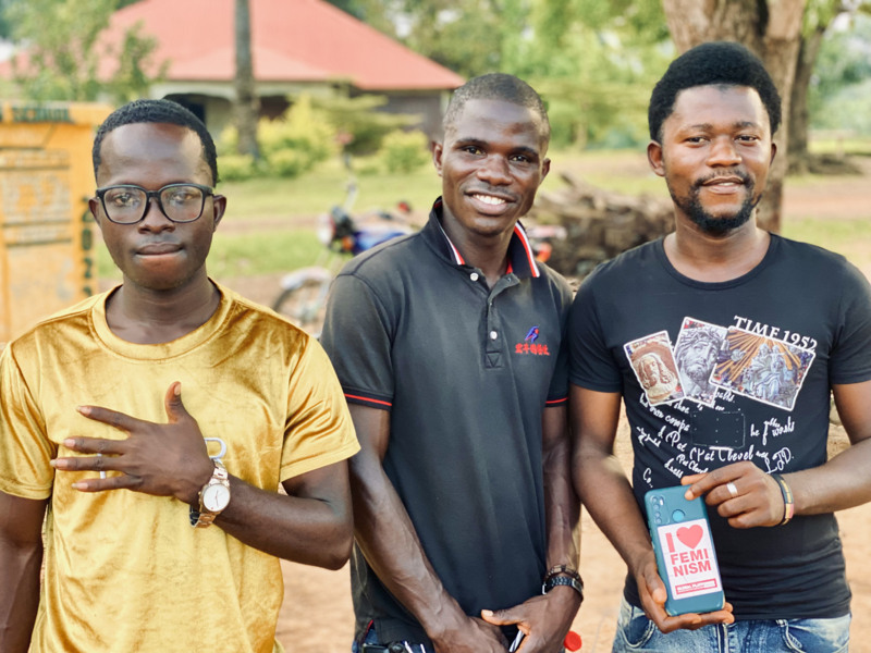 Tre män håller fram kampanjmaterial för att bekämpa kvinnlig könsstympning