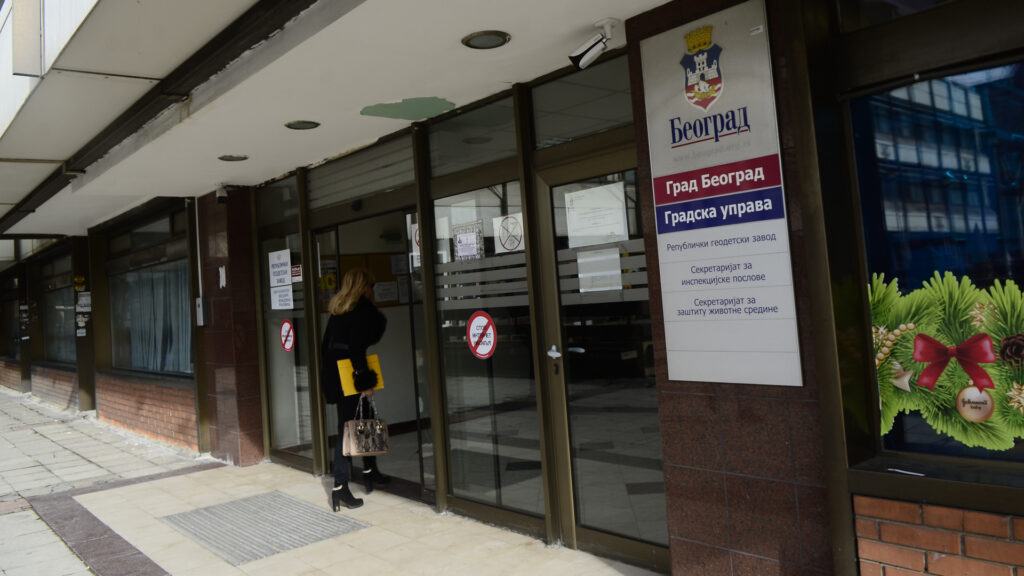 En kvinna går in genom dörren till en kontorsbyggnad.