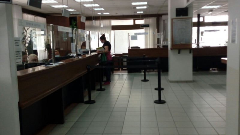 En kvinna står vid en servicelucka i en servicelokal.