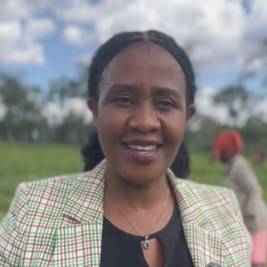 En med rutig kavaj kvinna ler.