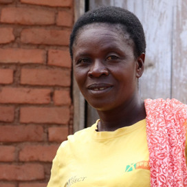 Porträtt på leende kvinna i gul t-shirt.