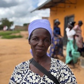 Kvinna poserar i blå huvudduk i Zimbabwe.