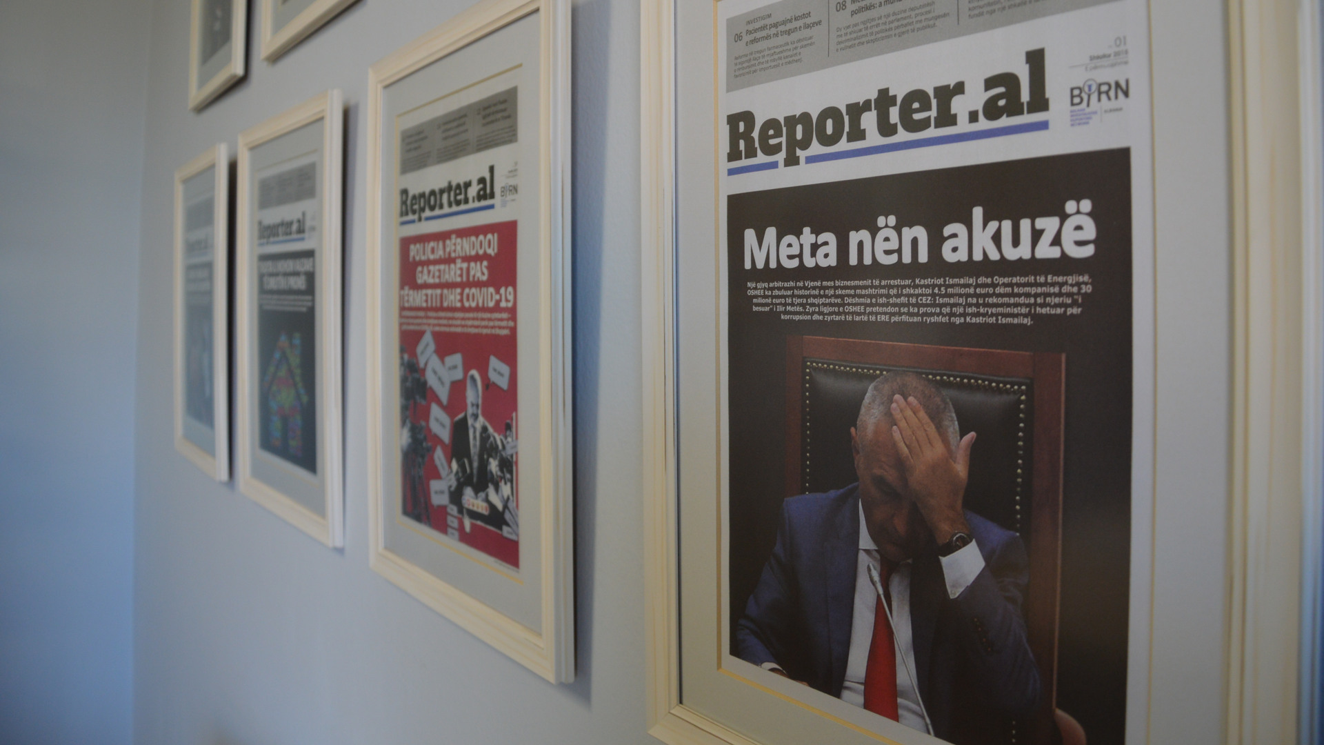 En vägg med en massa inramade tidningar på.