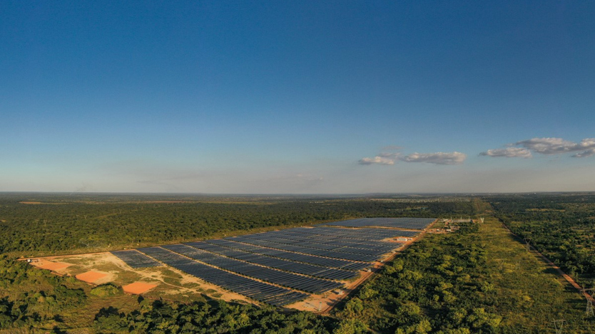 Flygbild på stor colcellsanläggning  bland omgiven av träd.