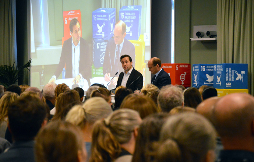 Benjamin Dousa talar framför Sidas medarbetare. Jakob Granit står också på scen.