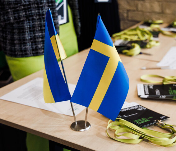 En ukrainsk och en svensk flagga står på ett bord.