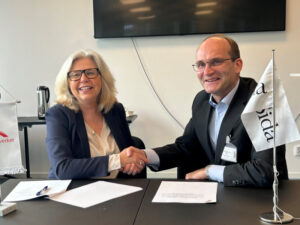 Migrationsverkets generaldirektör Maria Mindhammar (t.v.) och Jakob Granit skakar hand.