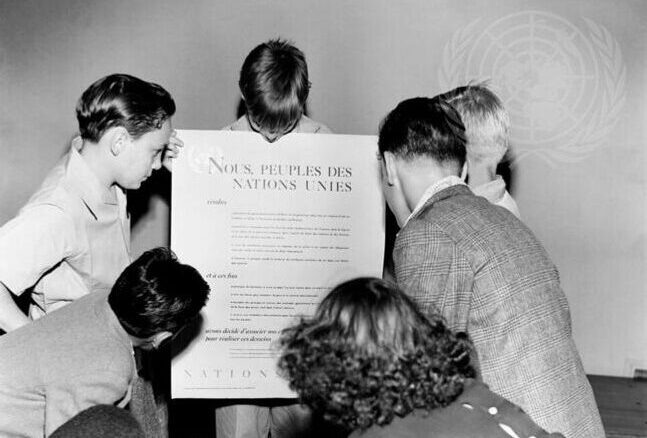 En grupp barn som står runt en skylt.