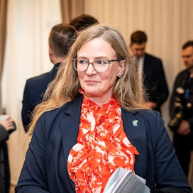 En kvinna i kostym som håller i en bok.