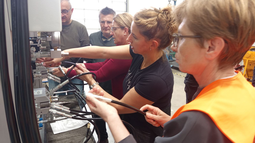 Fem personer arbetar med sladdar och teknik. 