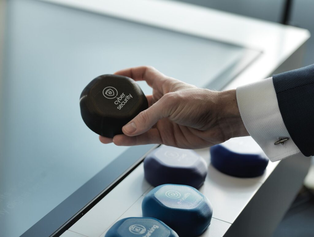 Man håller i en rund puck där det står cyber security.