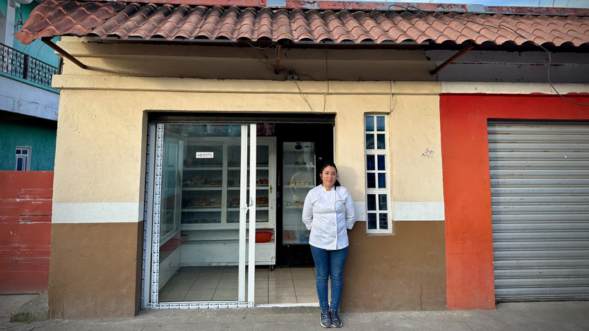 En kvinna som står i en dörröppning till en byggnad.