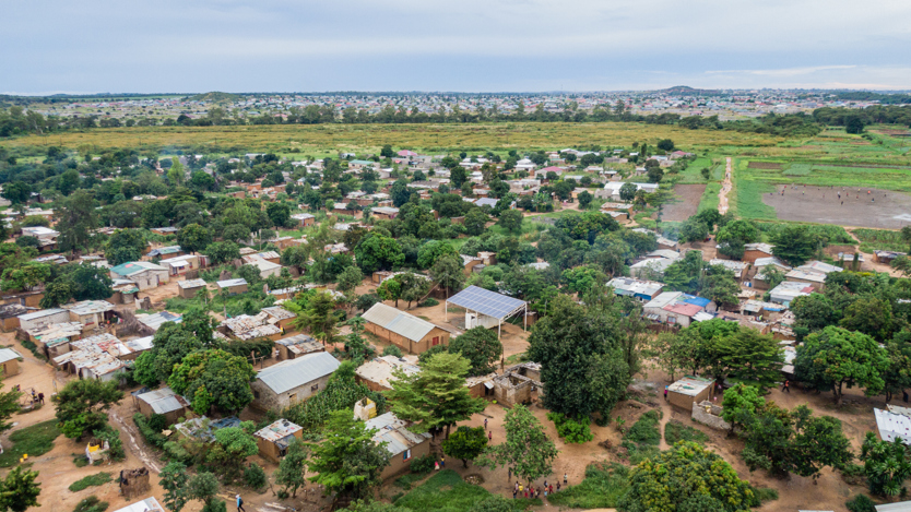 En flygbild av en liten by i afrika med en solcell i mitten. 