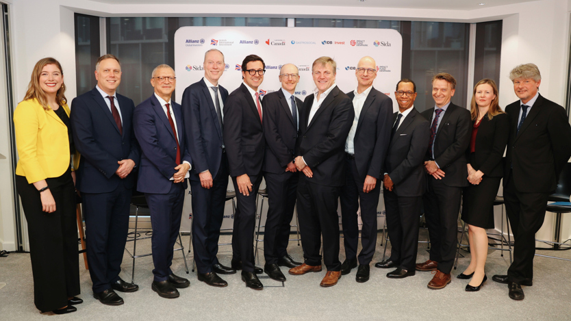 Gruppbild av 12 män och kvinnor i kostymer.