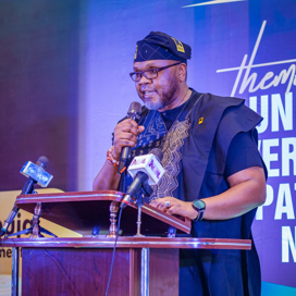 En man står i en talarstol och pratar i mikrofon.