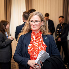 En kvinna i kostym som håller i en bok.