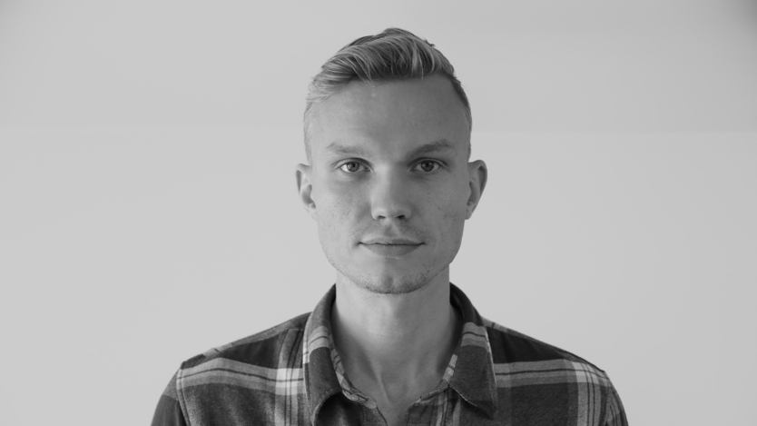 Ett svartvitt foto av en man i rutig skjorta.