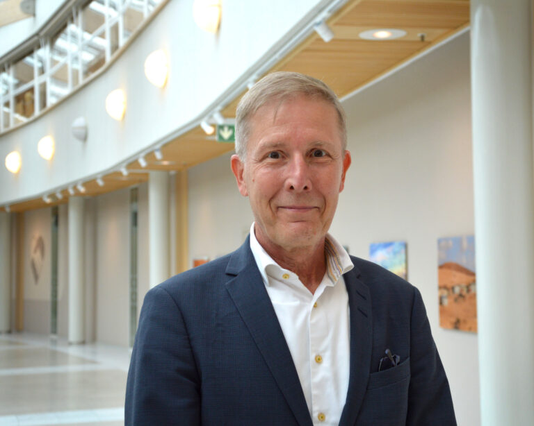 En kostymklädd man står i en byggnad.
